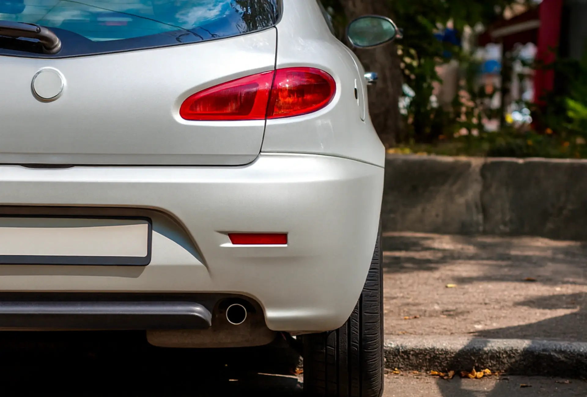 Heckansicht eines silbernen Autos mit leichten Beschädigungen am Stoßfänger