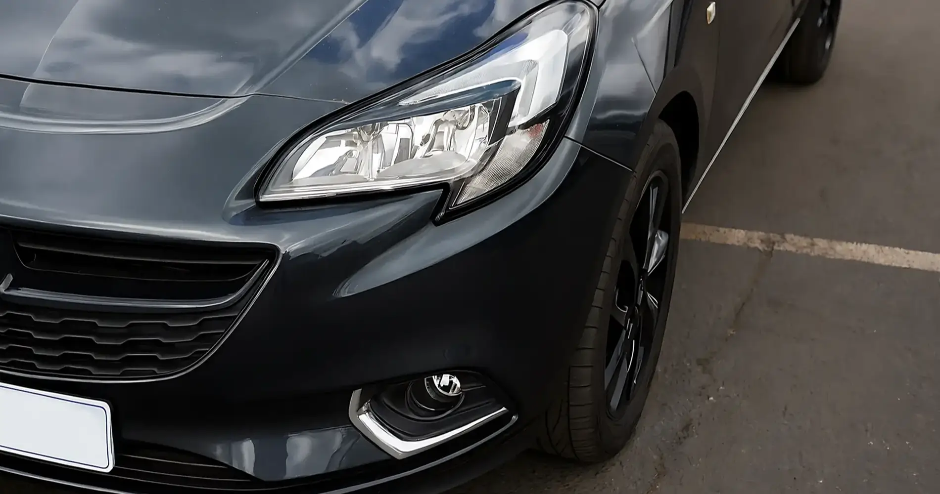 Detailbild schwarzes Auto mit Unfallschaden an der vorderen linken Fahrzeugseite